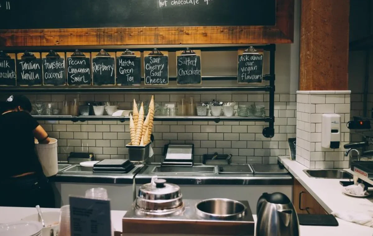 A cafe counter with a chalkboard menu on the wall