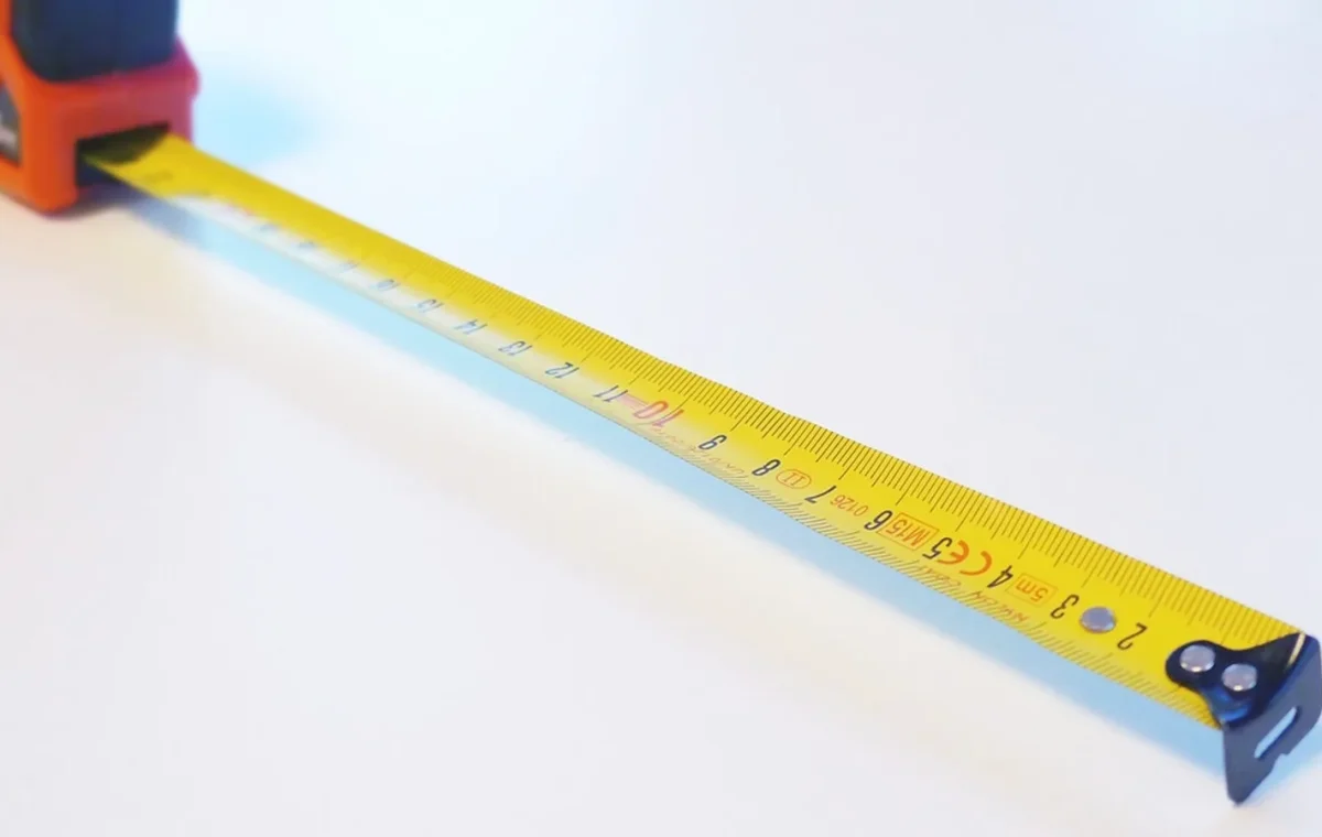 A steel tape measure pulled out across a table