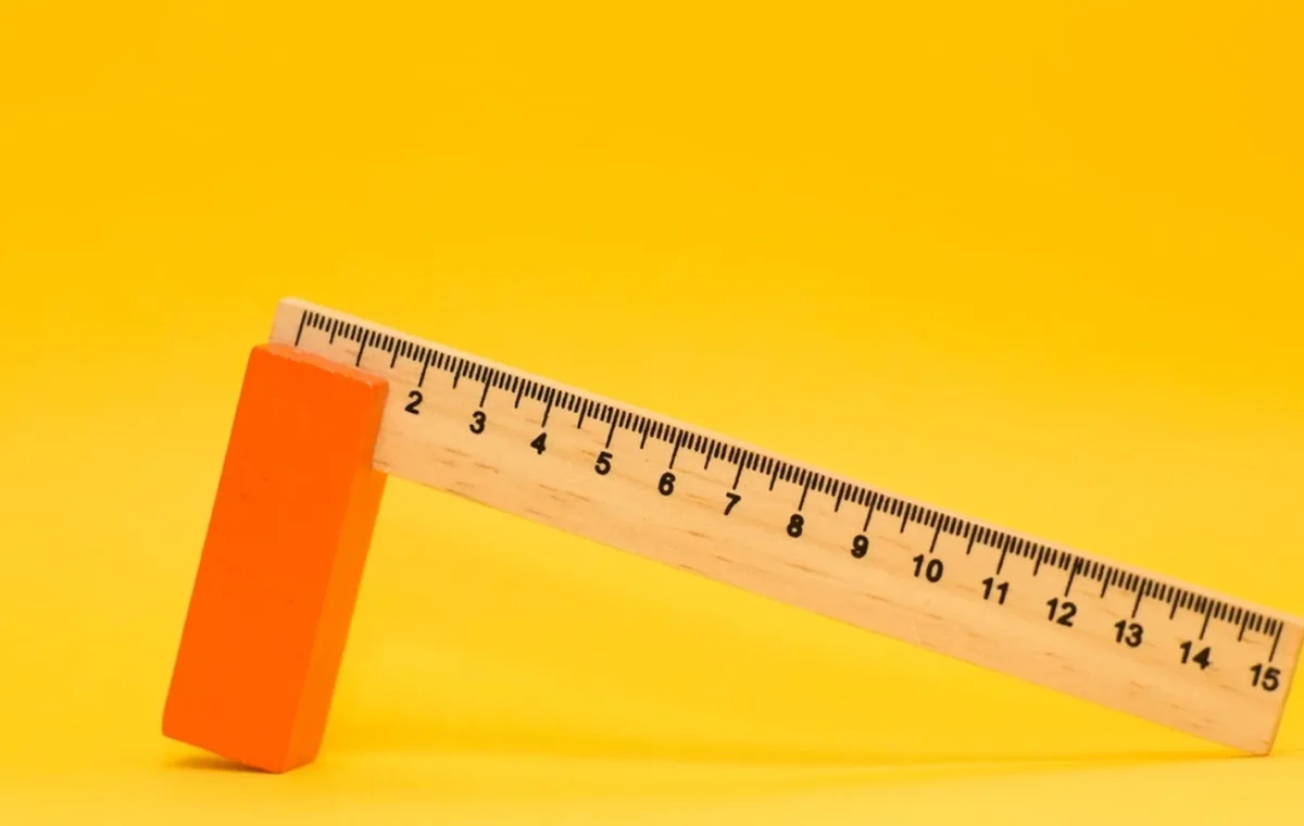 A wooden ruler on a yellow background